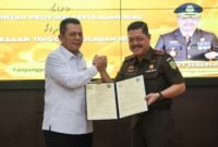Gubernur Kepri Ansar Ahmad dan Kepala Kejaksaan Tinggi Kepri J Devy Sudarso menunjukkan dokumen penyerahan hibah aset lahan di Kantor Kejati Kepri, Tanjungpinang, Kamis (16/4/2026). Foto: Diskominfo Kepri