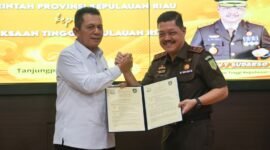 Gubernur Kepri Ansar Ahmad dan Kepala Kejaksaan Tinggi Kepri J Devy Sudarso menunjukkan dokumen penyerahan hibah aset lahan di Kantor Kejati Kepri, Tanjungpinang, Kamis (16/4/2026). Foto: Diskominfo Kepri