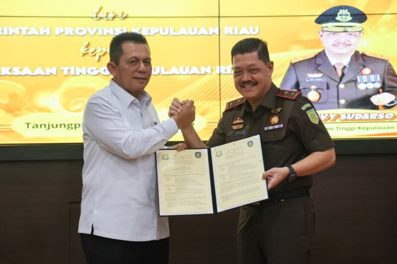 Gubernur Kepri Ansar Ahmad dan Kepala Kejaksaan Tinggi Kepri J Devy Sudarso menunjukkan dokumen penyerahan hibah aset lahan di Kantor Kejati Kepri, Tanjungpinang, Kamis (16/4/2026). Foto: Diskominfo Kepri