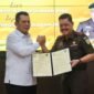 Gubernur Kepri Ansar Ahmad dan Kepala Kejaksaan Tinggi Kepri J Devy Sudarso menunjukkan dokumen penyerahan hibah aset lahan di Kantor Kejati Kepri, Tanjungpinang, Kamis (16/4/2026). Foto: Diskominfo Kepri