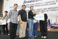 Wali Kota Batam, Amsakar Achmad, menyerahkan santunan Jaminan Kematian dari BPJS Ketenagakerjaan kepada ahli waris RT, RW, dan LPM di Gedung Serbaguna SP Plaza Sagulung, Minggu (26/4/2026). Foto: Humas Diskominfo Batam