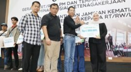 Wali Kota Batam, Amsakar Achmad, menyerahkan santunan Jaminan Kematian dari BPJS Ketenagakerjaan kepada ahli waris RT, RW, dan LPM di Gedung Serbaguna SP Plaza Sagulung, Minggu (26/4/2026). Foto: Humas Diskominfo Batam