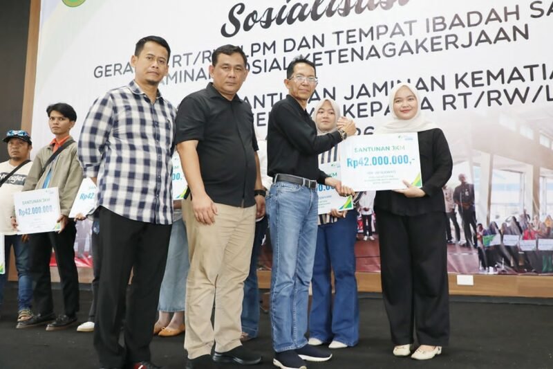 Wali Kota Batam, Amsakar Achmad, menyerahkan santunan Jaminan Kematian dari BPJS Ketenagakerjaan kepada ahli waris RT, RW, dan LPM di Gedung Serbaguna SP Plaza Sagulung, Minggu (26/4/2026). Foto: Humas Diskominfo Batam