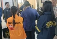 Penyidik OJK menyerahkan Komisaris sekaligus pemegang saham PT BPR DCN berinisial GK beserta barang bukti kepada Jaksa Penuntut Umum di Kejaksaan Negeri Batu, Kamis (2/7/2026). Foto: Istimewa