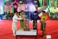 Gubernur Kepri Ansar Ahmad bersama Wagub Kepri sekaligus Ketua LPTQ Nyanyang Haris Pratamura menyerahkan tropi bergilir MTQ Kepulauan Riau kepada Wali Kota Tanjungpinang Lis Darmansyah pada pembukaan MTQ XII Tingkat Provinsi Kepri, Sabtu (4/7/2026) malam. Sebelumnya tropi diterima dari Wali Kota Batam Amsakar Achmad sebagai juara umum MTQ XI tahun 2025. Foto: Diskominfo Kepri
