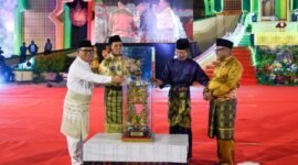 Gubernur Kepri Ansar Ahmad bersama Wagub Kepri sekaligus Ketua LPTQ Nyanyang Haris Pratamura menyerahkan tropi bergilir MTQ Kepulauan Riau kepada Wali Kota Tanjungpinang Lis Darmansyah pada pembukaan MTQ XII Tingkat Provinsi Kepri, Sabtu (4/7/2026) malam. Sebelumnya tropi diterima dari Wali Kota Batam Amsakar Achmad sebagai juara umum MTQ XI tahun 2025. Foto: Diskominfo Kepri