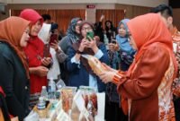 Ketua Dekranasda Kota Batam, Erlita Amsakar, mengecek kemasan salah satu IKM Batam saat membuka pelatihan Pelatihan Digitalisasi Pemasaran di Kantor Wali Kota Batam, Selasa (7/7/2026). Humas Diskominfo Batam