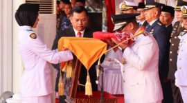 Wakil Gubernur Kepri, Nyanyang Haris Pratamura mencium bendera merah putih yang diserahkan Nurjihan Dwi Hanifah, Paskibraka yang bertugas membawa baki pada Upacara Penurunan Bendera Peringatan HUT ke-81 di Gedung Daerah, Tanjungpinang, Senin (17/8/2026). Foto: Diskominfo Kepri