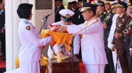 Gubernur Kepulauan Riau Ansar Ahmad menyerahkan Bendera Merah Putih kepada Yuanita Putri Verinda, pembawa baki Paskibraka dalam Upacara Peringatan HUT ke-81 Republik Indonesia di Gedung Daerah Tanjungpinang, Senin (17/8/2026). Foto: Diskominfo Kepri