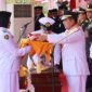 Gubernur Kepulauan Riau Ansar Ahmad menyerahkan Bendera Merah Putih kepada Yuanita Putri Verinda, pembawa baki Paskibraka dalam Upacara Peringatan HUT ke-81 Republik Indonesia di Gedung Daerah Tanjungpinang, Senin (17/8/2026). Foto: Diskominfo Kepri