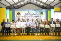 Wali Kota Batam, Amsakar Achmad, menyerahkan insentif saat menghadiri Silaturahmi bersama RT/RW, LPM, dan Tokoh Masyarakat se-Kecamatan Sekupang di Aula SMP Kartini Sei Harapan, Kecamatan Sekupang, Minggu (4/10/2026) malam. Foto: Humas Diskominfo Batam